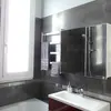 View of the bathroom with a large window, bathtub, shower, lavatory, cabinet with mirror 