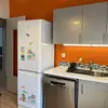 The kitchen is separated, offering a large space for cooking and eating, with an access to a small balcony