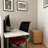 There is a dedicated workspace in the living room with a desk, a comfortable desk chair, a screen with HDMI connection, mouse pad and keyboard